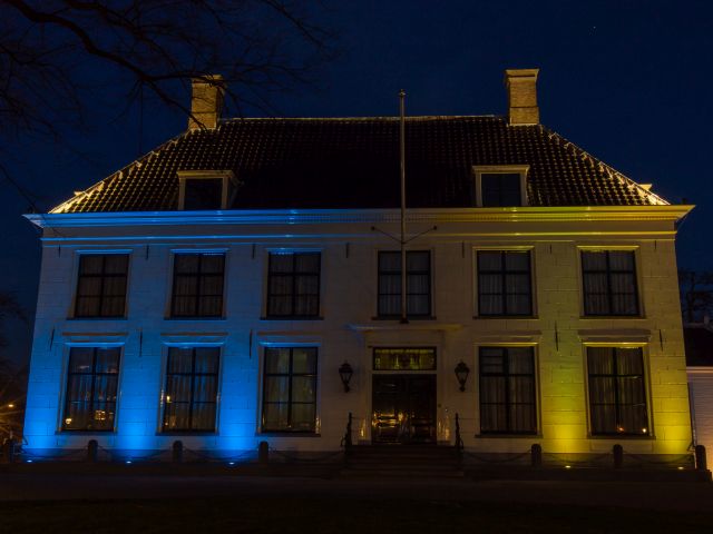 Gemeentehuis geel en blauw verlicht